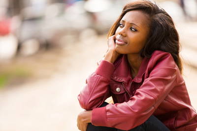 Young african woman daydreaming outdoors