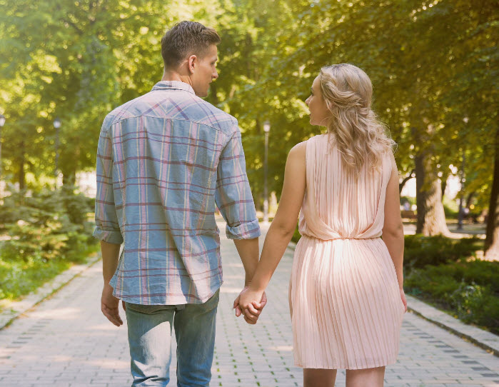 Couple in love strolling through beautiful summer park